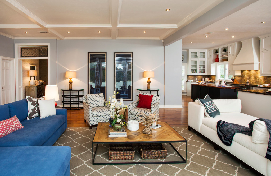 Blues and neutrals combine for a sophisticated, eclectic look in the living room. Accessories from the couple’s travels add to the mix. A wall was removed, opening up the kitchen to the living space. A majority of fabrics are from Mary McDonald for Schumacher. 