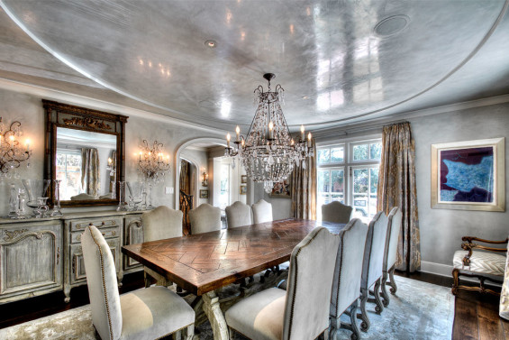 In the dining room, the same color plaster was applied on the walls and ceilings to lend height to the lower ceilings and accentuate the oval inset in a subtle, sophisticated way. A car buffer was used to apply polished wax to the ceiling, creating a dramatic effect for night time entertaining. Sources: Schumacher Gainsborough fabric on custom Mutton Bone chairs, custom rock crystal chandelier, table, art and mirror from Boxwood Interiors. Oriental Tibetan rug by Stark. Plaster on walls and waxed ceiling by Segreto