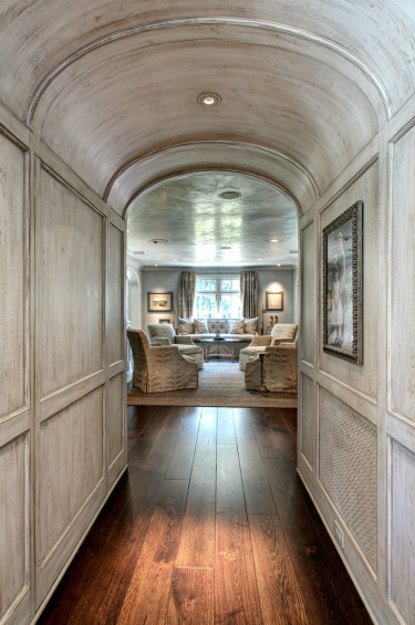 The vestibule between the den and the living room has paneling painted by Segreto to create the illusion of reclaimed wood, balancing the transitional nature of the formal living space with the more casual den.
