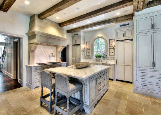 In the kitchen, a lighter tone plaster was applied than in the rest of the home. The cabinets were glazed to create a country French feel. Sources: Custom barstools from Boxwood Interiors. Plaster walls and range hood and glazed cabinet finish by Segreto.
