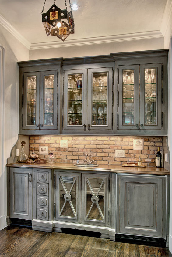 In the mudroom, backsplash and handmade terra cotta tiles from Architectural Design Resource, exposed beams (faux-finished to look old) and a farmhouse kitchen sink make this space chic and inviting.