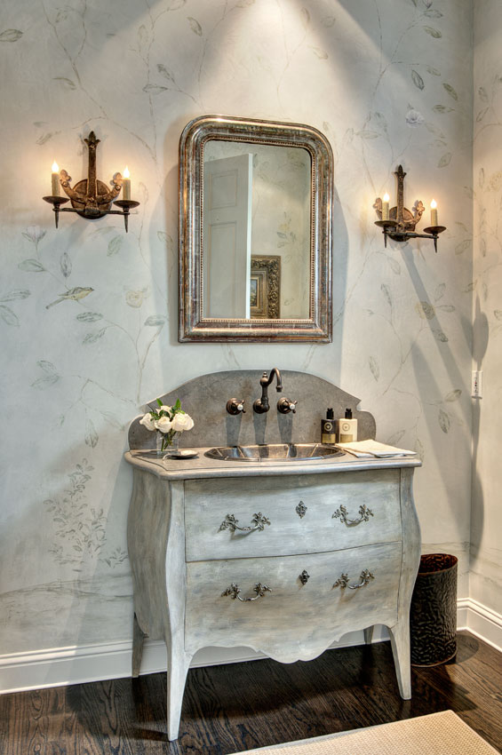 The powder room walls were plastered using the antique console piece from Vieux for color inspiration, then finished with a hand-painted, very soft Grazie inspired design on the walls. Sconces are from Brown.