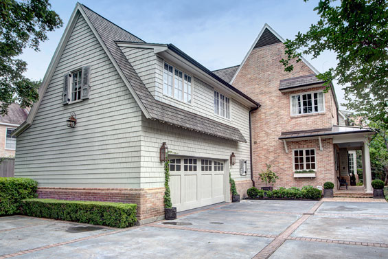 The steep roof lines make for a dramatic exterior façade. The driveway of this home, large and expansive to allow room for guest parking when the couple entertains, includes a unique feature: paw prints of Millie Bush who lives just down the street.
