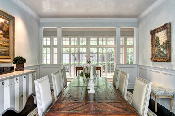 The dining room, previously a boxed- in room, was opened to the gallery of windows when the couple renovated. The walls were plastered with a diamond plaster, giving a reflective quality to the room. The room’s design is a blend of styles — traditional, contemporary, French — which are reflected throughout the home. The impressive buffet is from Roche Bobois.