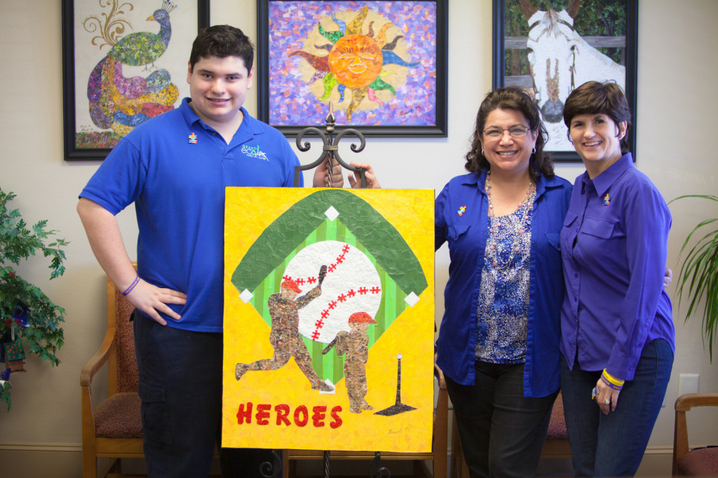(L-R) Eco-artist Grant Manier with his mother, Julie Coy Manier, Darla Farmer, and the “Heroes” artwork he created for this year’s Strike Out Autism auction. The work contains more than 2,500 puzzle pieces