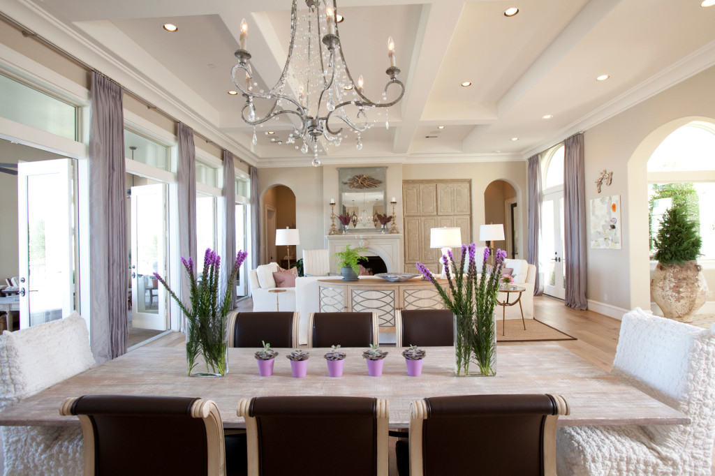 The dining and living rooms flow seamlessly together in this open floor plan, allowing diners to enjoy the fireplace during mealtimes. Dining chairs came from the homeowners’ previous home and were refinished and reupholstered in a Brentano Vinyl. The mirror over the fireplace was a Round Top find.