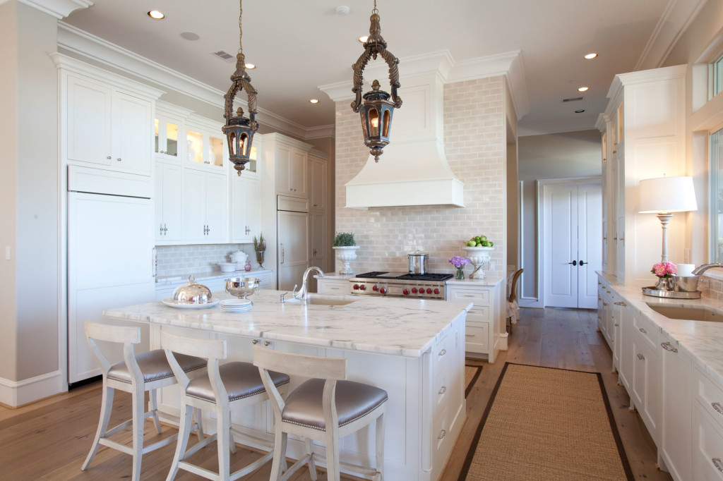 The all-white kitchen exudes a fresh, clean aesthetic. The homeowners selected honed Calacatta Marble; backsplash from Walker Zanger; island lighting from Tara Shaw.