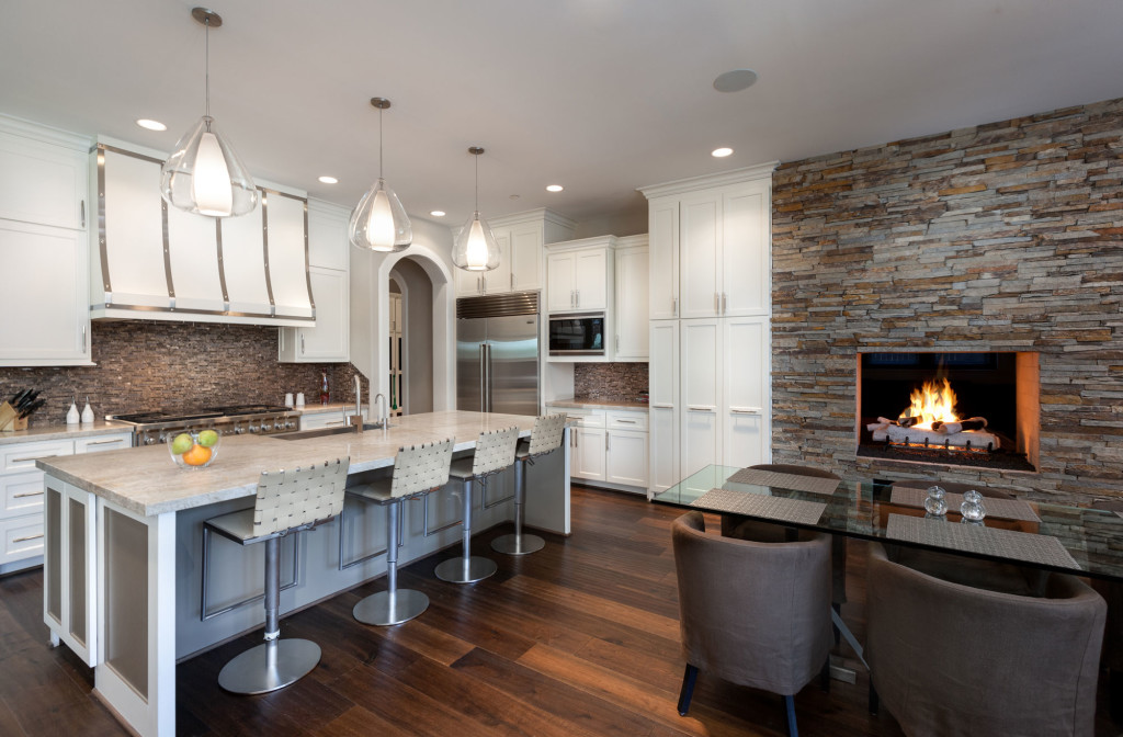 A stone wall frames a fire place in the breakfast area.