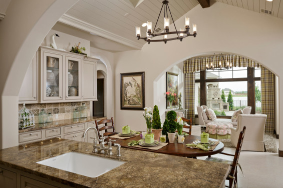 Fabulous and functional, the kitchen opens to a morning room overlooking the lake. It also features Thermador appliances provided by Ferguson, including a 48-inch refrigerator, six-burner stove, double oven and warming oven. Overhead, a half dome ceiling soars and impresses, while the shiplap ceiling treatment adds rustic warmth, and the Velux skylight delivers natural sunlight. The built-in gracefully curved banquette harmonizes with the Wellborn painted cabinets. Tile by Emser Tile; “Autumn Leaves” granite countertops by Hilltop Granite.