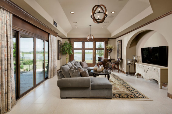 The multi-function game room features one whole wall of sliding doors that offer another gorgeous lake view, and open to the patio and outdoor kitchen. It features automated black-out window treatment and drop-down screen and projector so the room can be instantly darkened for use as a media room.