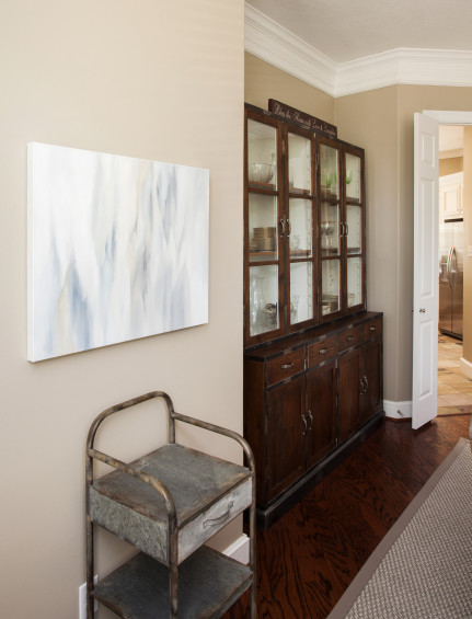 The homeowner’s mother painted this soft abstract pastel piece that hangs above a vintage medical cabinet in the dining room.
