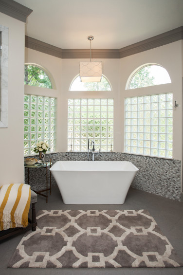 The master bathroom was treated to a transformation with this beautiful marble-blend backdrop accenting the stand-alone bathtub.