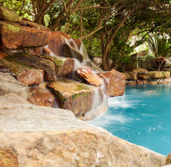 The backyard captures that resort feel with a stone waterfall feature accenting the pool.