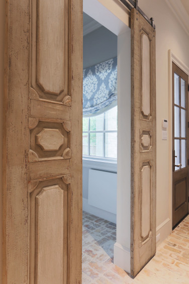 Custom-carved sliding doors from reclaimed wood easily open and close to mom’s home office refuge.