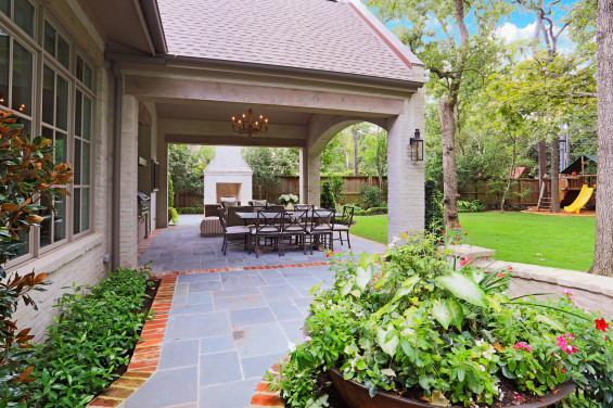 The backyard terrace is a wonderful mixture of antique brick liner, Pennsylvania blue stone and slurried antique brick. The sugar kettle overflowing with seasonal flowers and the Bevolo gas lanterns are a must for this Southern Louisiana native.