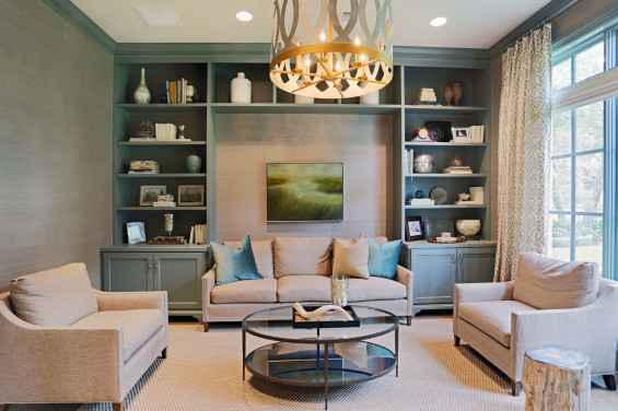 The library off the main entry is a transitional contrast to the more French country design found elsewhere in the home. High gloss enameled cabinetry and grass cloth on the walls create a modern space to entertain.
