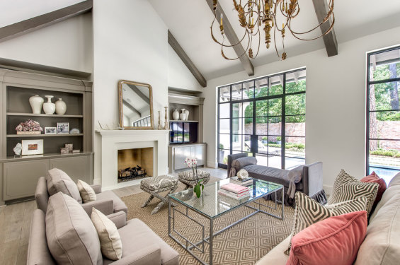 The family room boasts a vaulted ceiling and exposed beams and large windows which flood the space with natural light. Custom crafted furniture personalizes the décor to the homeowner’s taste. Club chairs with pillows appliqued by Mary McDonald, Schumacher; cocktail table with silver leaf finish; day bed and bolsters, fabric by Lee Jofa; stools, fabric by High Fashion Home; sofa by Kravet; sofa pillows by Schumacher; Louis Philippe mirror from Round Top; and rug from Creative Flooring.