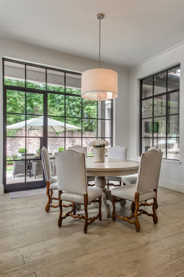 The breakfast area utilizes antique mutton chairs from the couple's previous home. Drum light fixture by Jonathan Adler.