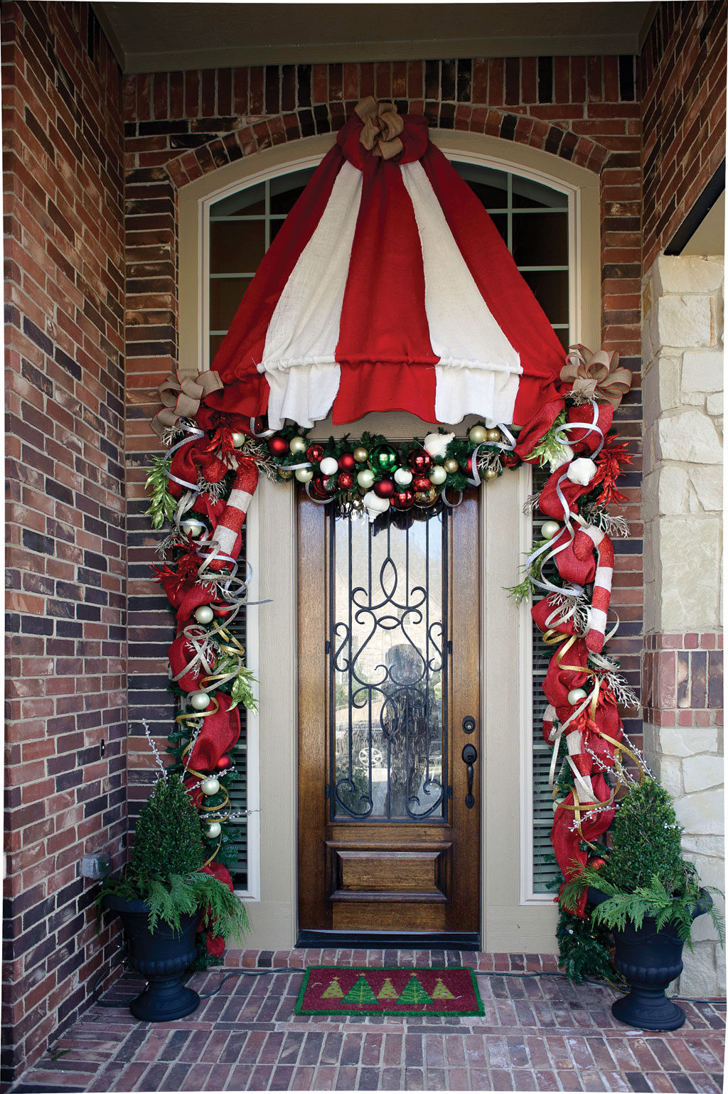 This home's holiday theme "Under the Big Top" is evident at the front door, with red and ivory burlap in addition to ceramic candy canes and hand-painted ivory ornaments.