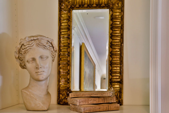 A stone bust, Italian framed mirror and French paper books from Joyce Horn mingle in the living room.