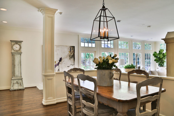 A cozy breakfast room is light and bright thanks to expansive windows. Table and chairs are from MAI, lighting from Brown. The Swedish clock and large abstract painting by artist Michelle Williams in the background are from Twenty Six Twenty and Area, respectively.