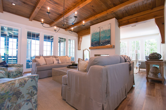 The living room is comfortable and functional with custom slipcover sofas in Slubby Greystone fabric and matching Kylee XL Chairs in Vinaya Sapphire Fabric from Four Seasons; honeycomb ivory and gray rug from Dash & Albert; custom metal fire screen from MSM Imports; local driftwood.