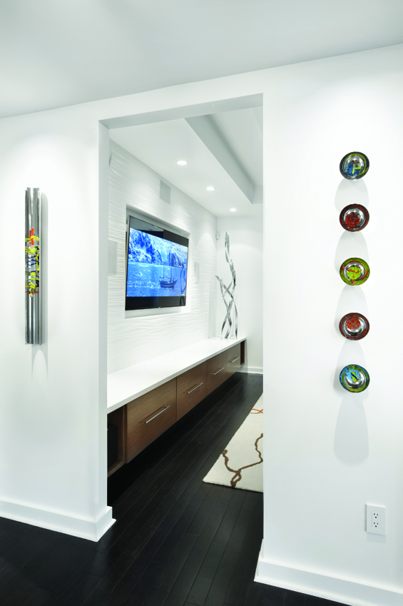 View from entry into living room. Artist Navid Ghedami was commissioned to create the sculptures flanking this pass through. As well, Ghedami was commissioned to create the sculpture in the background. Oxo Line Blanco tile from Porcelanosa covers the wall beyond.