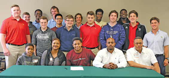(Front row, l-r): Brother Devin Smith, mom Tanya Smith, Lynell Smith, dad Lynell Smith, Sr., and Pastor Robert Simpson. (Back row): Some of the members of the FBCA varsity football team.
