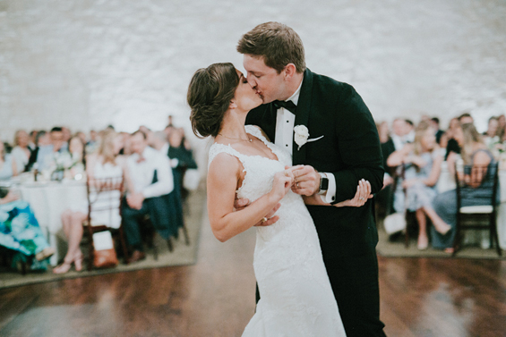 A husband kisses his wife on the dance floor.