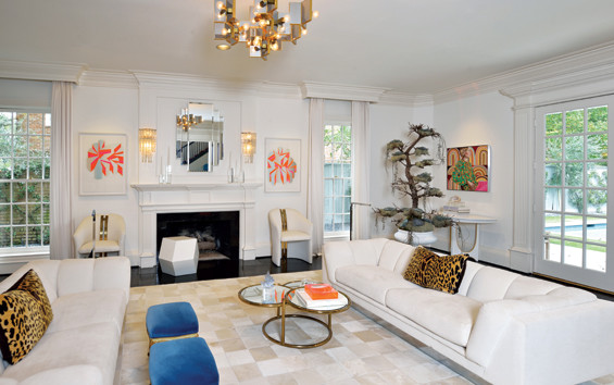 The monochromatic walls and furnishings provide a perfect backdrop for the McCabes’ art collection. The bonsai tree arrangement in the background is a contemporary take on a holiday tree.The living room art is by Jeffrey Dell and Jocelyn Hobbie.
